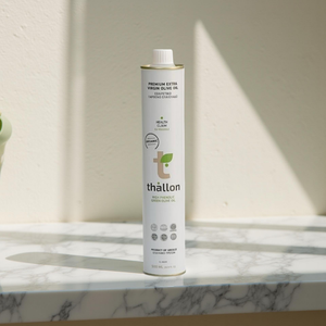 Thallon olive oil can on a marble surface with a neutral background