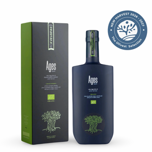 A bottle of Ages olive oil next to its packaging box, featuring a dark navy blue bottle and a black and green box, with a blue 'New Harvest 2026 - 2027 The Olivate Selection' badge in the top right corner.